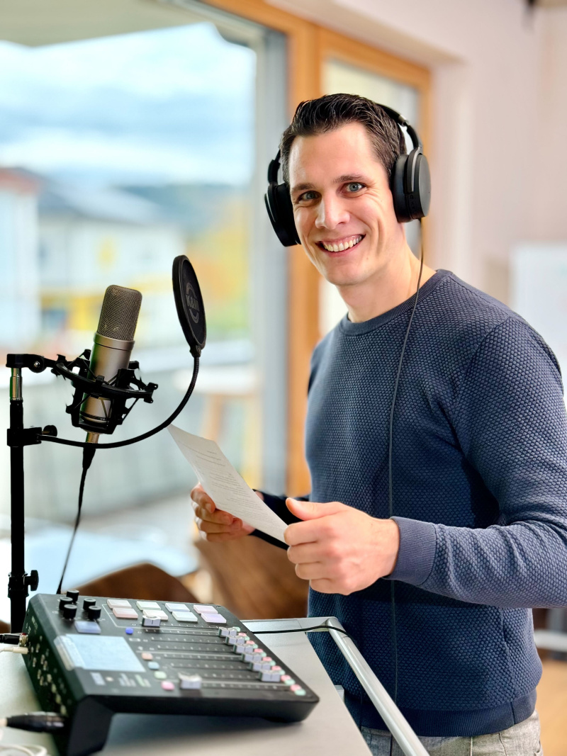 Andreas Punz mit Mikrophone und Kopfhörer beim Einsprechen für den Podcast Kommunal Kompass